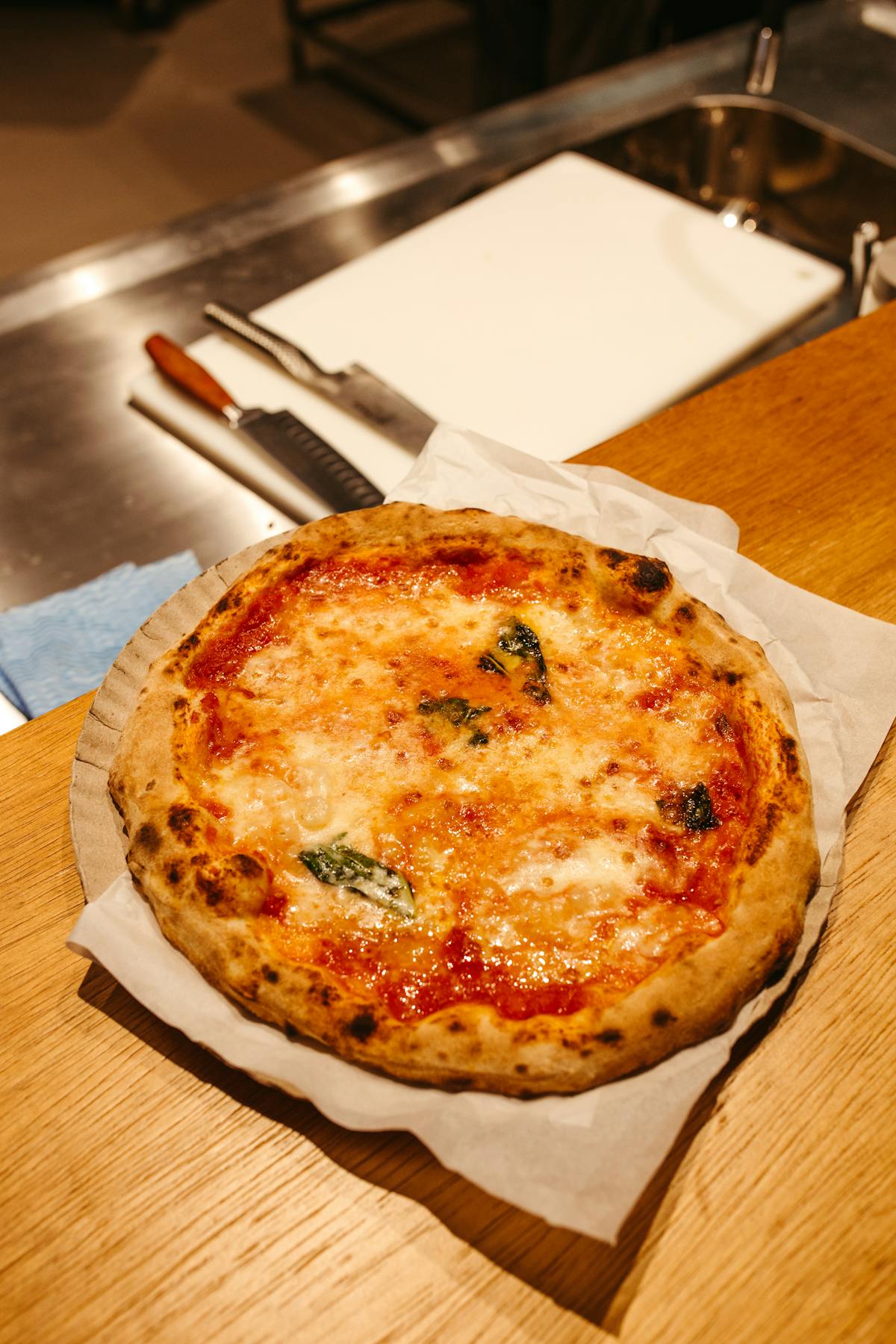 A classic Neapolitan margherita pizza with charred crust and fresh mozzarella on a metal plate