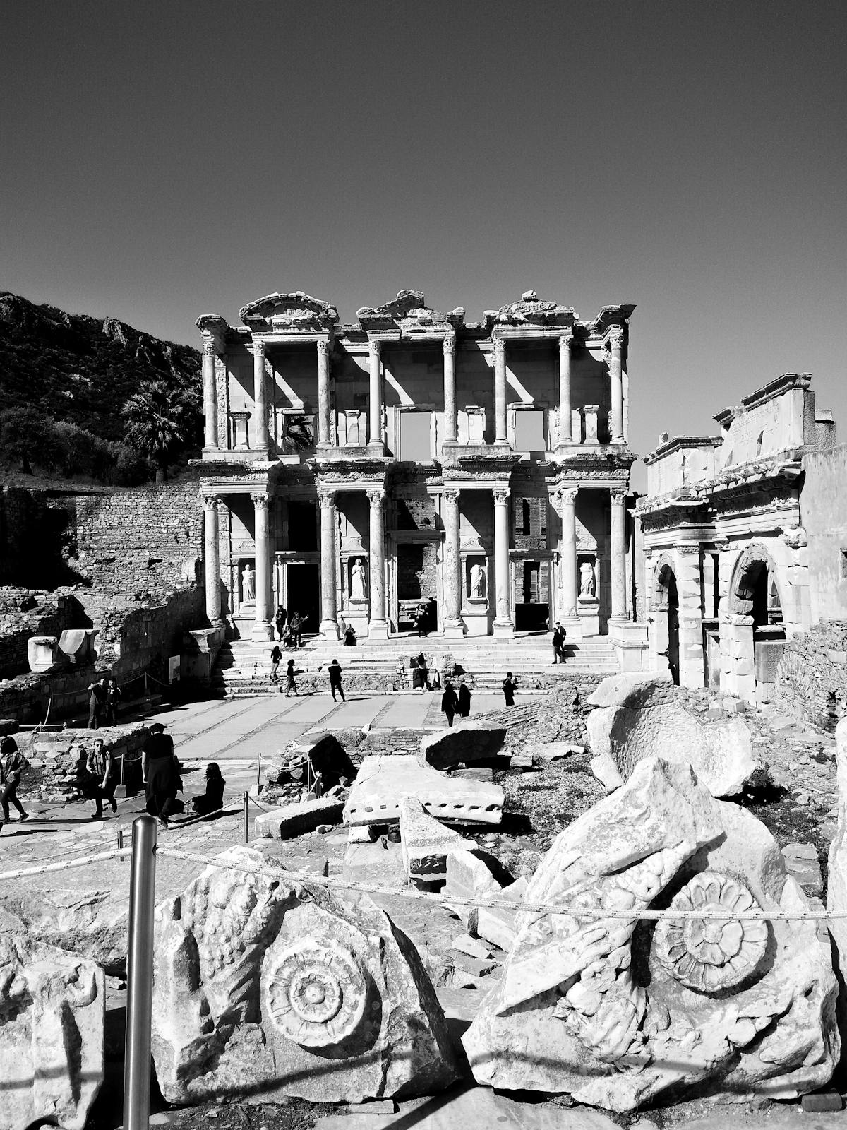 Ancient stone-paved street in Pompeii with deep cart ruts, raised sidewalks, and ruined buildings on both sides